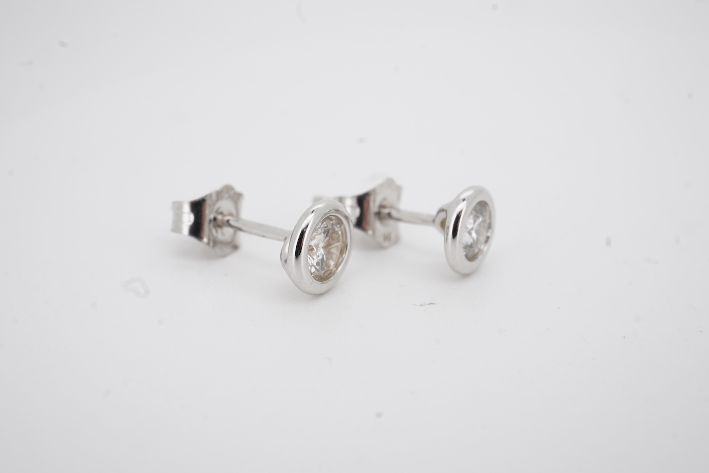 A modern pair of white metal (stamped 375) and solitaire lab-grown synthetic diamond set ear studs, each stone weighing approximately 0.15-0.20ct.